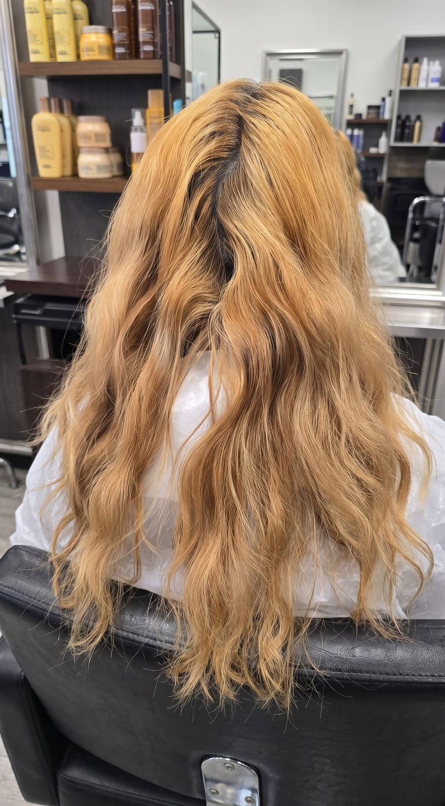 Capelli biondi con riflessi ramati e ricrescita scura, prima del trattamento