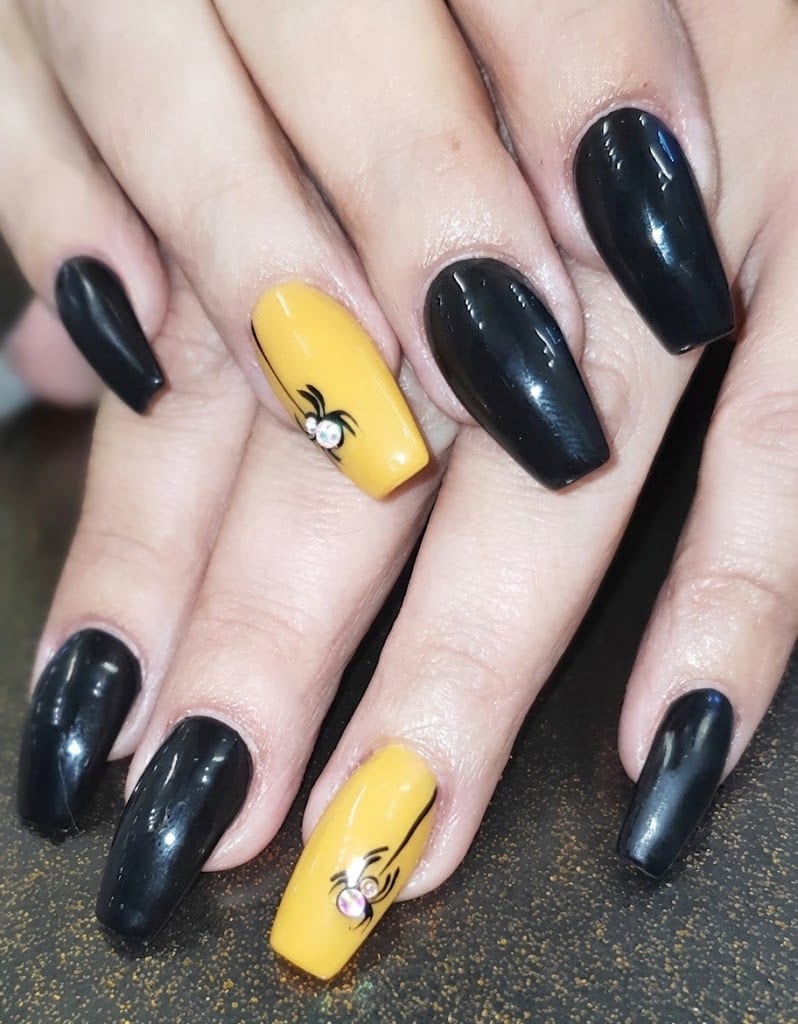 Unghie nere con dito giallo e ragnetto dipinto, nail art di Halloween
